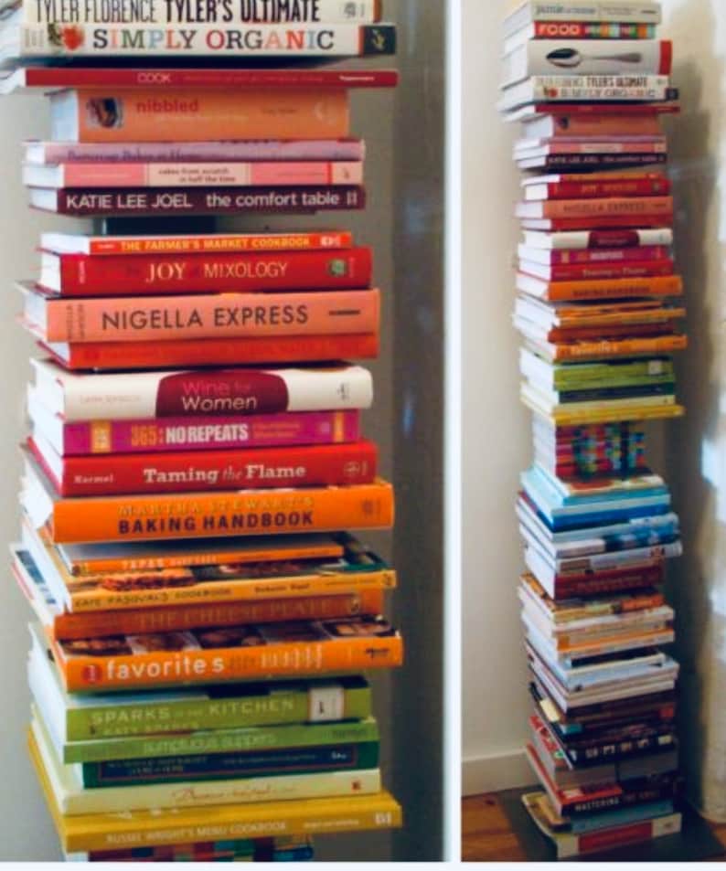 K&ouml;nnte beinhalten: Ein Stapel Kochb&uuml;cher mit bunten Umschl&auml;gen, darunter Titel wie "Simply Organic", "The Comfort Table II", "Joy Mixology" und "Taming the Flame".