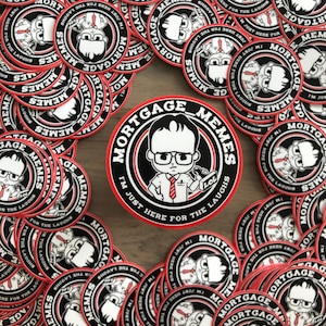 May include: A collection of round stickers with a red and black design. The stickers feature the text "MORTGAGE MEMES" and an illustration of a cartoon character. The phrase "I'M JUST HERE FOR THE LAUGHS" is also included.