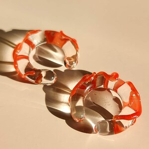 Skulptural öronmanschett i glas – Statement-öronmanschett i klart och korallrosa glas – Djärva sommarsmycken i statement-stil – Unik sommarstil utan piercing