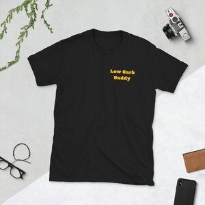 Op de afbeelding: Zwart T-shirt met de tekst "Low Carb Daddy" in geel.