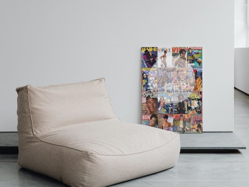 May include: A beige beanbag chair sits next to a framed collage of magazine covers. The collage features various magazine covers with people on them. The words "Made with Love" are visible on the collage.