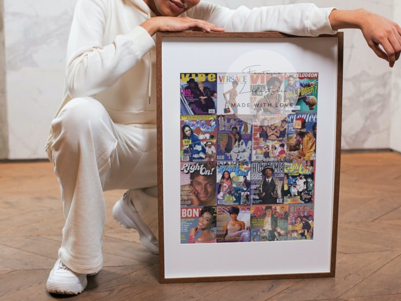 May include: A framed collage of magazine covers with a brown wooden frame. The covers feature various celebrities and the text "I MADE WITH LOVE". The frame is held by a person wearing a white sweatsuit.
