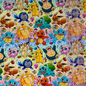 Puede incluir: Una tela colorida con un patr&oacute;n repetitivo de personajes de dibujos animados. Los personajes son de la franquicia Pokemon e incluyen Pikachu, Bulbasaur, Charmander, Squirtle y otros. La tela es un degradado arco&iacute;ris con un fondo blanco.