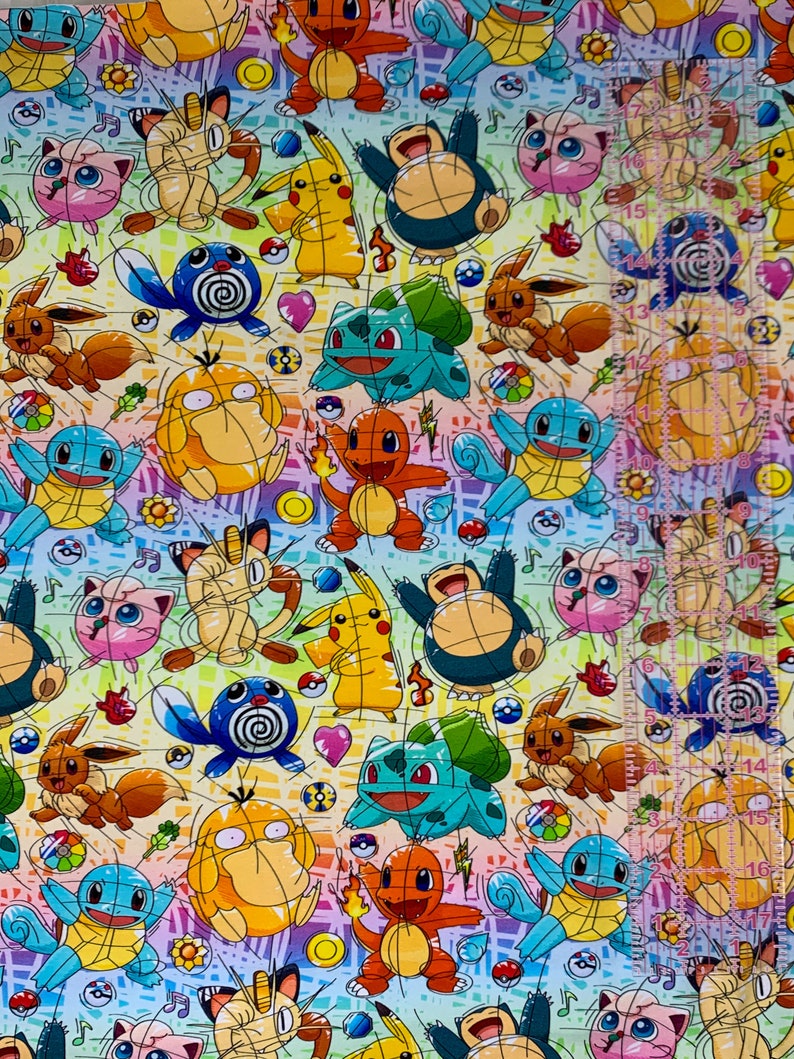 Puede incluir: Una tela colorida con un patr&oacute;n repetitivo de personajes de dibujos animados. Los personajes son de la franquicia Pokemon e incluyen Pikachu, Bulbasaur, Charmander, Squirtle y otros. La tela es un degradado arco&iacute;ris con un fondo blanco.