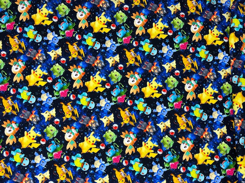 Puede incluir: Una tela negra con un patr&oacute;n repetitivo de personajes de dibujos animados amarillos, azules y verdes. Los personajes est&aacute;n sobre un fondo estrellado azul y negro.