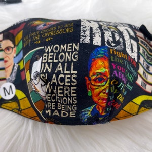 May include: Black face mask with a colorful collage of images and text, including a portrait of Ruth Bader Ginsburg, the quote "Women belong in all places where decisions are being made", and the text "Fight for the things you care about, but it's a good fight".