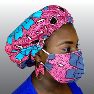 May include: A matching set of a pink floral patterned bonnet, face mask, and earrings. The bonnet and mask feature a repeating pattern of blue and white floral shapes on a pink background. The earrings are gold hoops with a fabric bow.