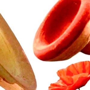 May include: A close-up of three red poppy flower decorations. The flowers are made of a soft, pliable material and have a realistic appearance. The flowers are arranged in a way that suggests they are falling or floating.