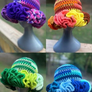 May include: Four crocheted hats with ruffled brims in different color combinations. The hats are displayed on mannequins. The colors include purple, pink, orange, yellow, green, blue, and white.