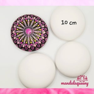Könnte beinhalten: Vier runde, weiße Steine, einer mit einem handgemalten Mandala-Design in Pink, Schwarz und Gold. Ein Stein ist mit "10 cm" beschriftet. Der Mandala-Stein hat einen zentralen rosa Punkt, der von komplizierten Mustern umgeben ist. Das Logo "mandalaqueeny" ist sichtbar.
