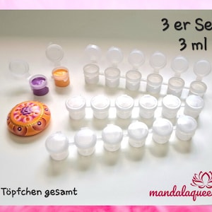 Könnte beinhalten: Ein Set mit 18 kleinen Farbtöpfen, jeder mit einem Deckel. Die Töpfe sind in Reihen angeordnet, mit drei Töpfen in jeder Reihe. Die Töpfe sind weiß und die Deckel sind klar. Drei Töpfe sind mit Farbe gefüllt, einer lila, einer gelb und einer orange. Der Text "3 er Set 3 ml" und "18 Töpfchen gesamt" ist im Bild sichtbar. Der Text "mandalaqueeny" ist ebenfalls im Bild sichtbar.