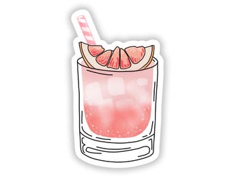Puede incluir: Un cóctel de pomelo rosa con una pajita de rayas rosa y blancas en un vaso con hielo. La bebida está coronada con una rodaja de pomelo.