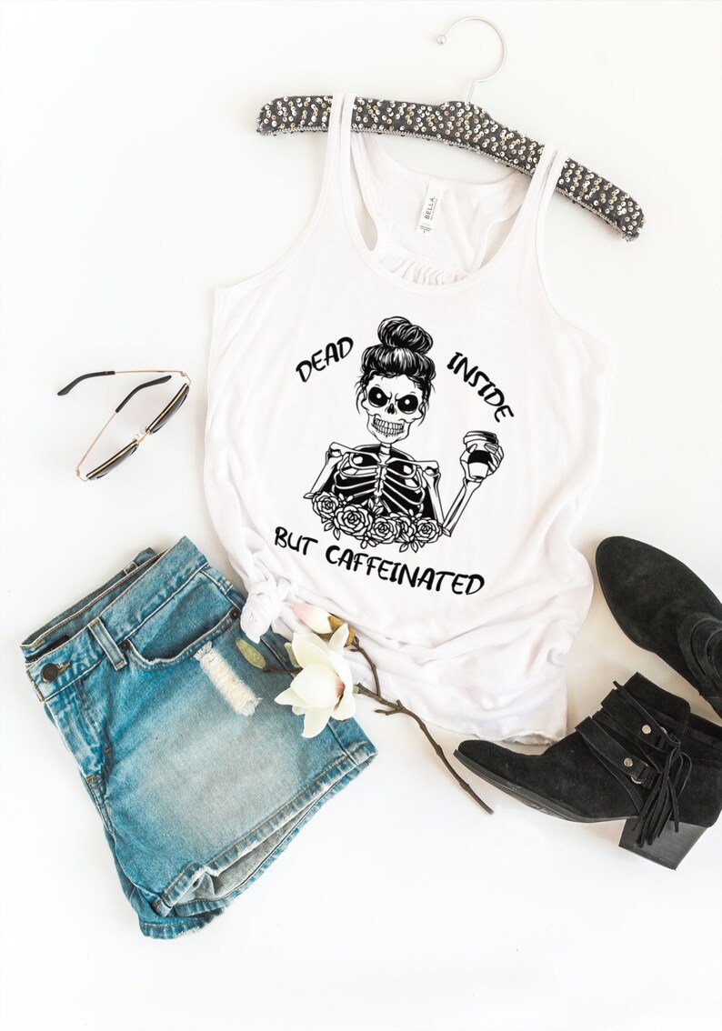 May include: White tank top with a black and white illustration of a skeleton holding a coffee cup. The text "Dead Inside But Caffeinated" is printed on the shirt.