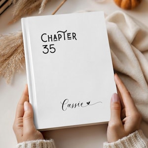 May include: A white ceramic mug with a black handle and the text "But First, Coffee" in a bold, black font. The mug is set against a blurred background, suggesting a cozy setting.