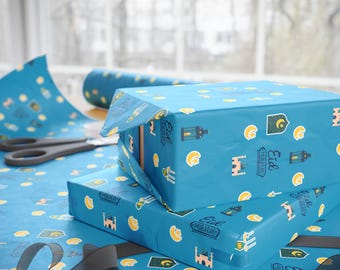 May include: A stack of blue gift wrap with a pattern of crescent moons, lanterns, and the text "Eid Mubarak".