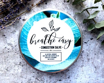 Puede incluir: Una lata de plata con un diseño floral azul y blanco. La etiqueta dice "breathe easy - CONGESTION SALVE - ALL-NATURAL, HANDMADE WITH 100% PURE ESSENTIAL OILS OF EUCALYPTUS, PEPPERMINT AND LAVENDER"