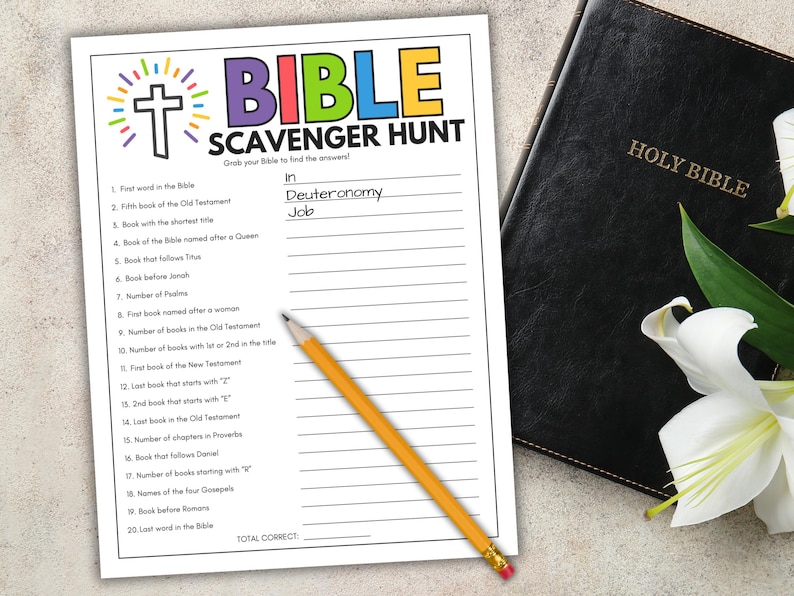 May include: A Bible Scavenger Hunt worksheet with a cross and colorful text. The worksheet is next to a closed Holy Bible and a pencil. The answers "Deuteronomy" and "Job" are written on the worksheet.