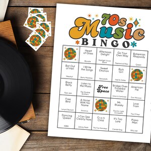 May include: A 70s Music Bingo game sheet with a retro design, featuring song titles and a disco ball graphic. Includes a vinyl record and bingo markers with matching disco ball designs. The text "70s Music Bingo" is prominently displayed.