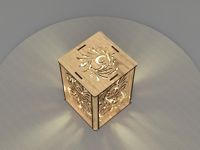 May include: A wooden lamp with a decorative cutout design on all sides. The lamp is lit and casting a warm glow.