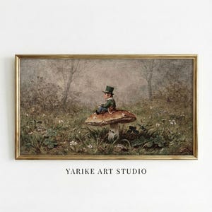 Könnte beinhalten: Ein gerahmter Druck einer skurrilen Szene. Eine kleine Figur in grüner Kleidung und Zylinder sitzt auf einem großen Pilz in einem Feld. Das Kunstwerk hat eine Vintage-Ästhetik, mit einem goldenen Rahmen und dem Text "YARIKE ART STUDIO" unten.