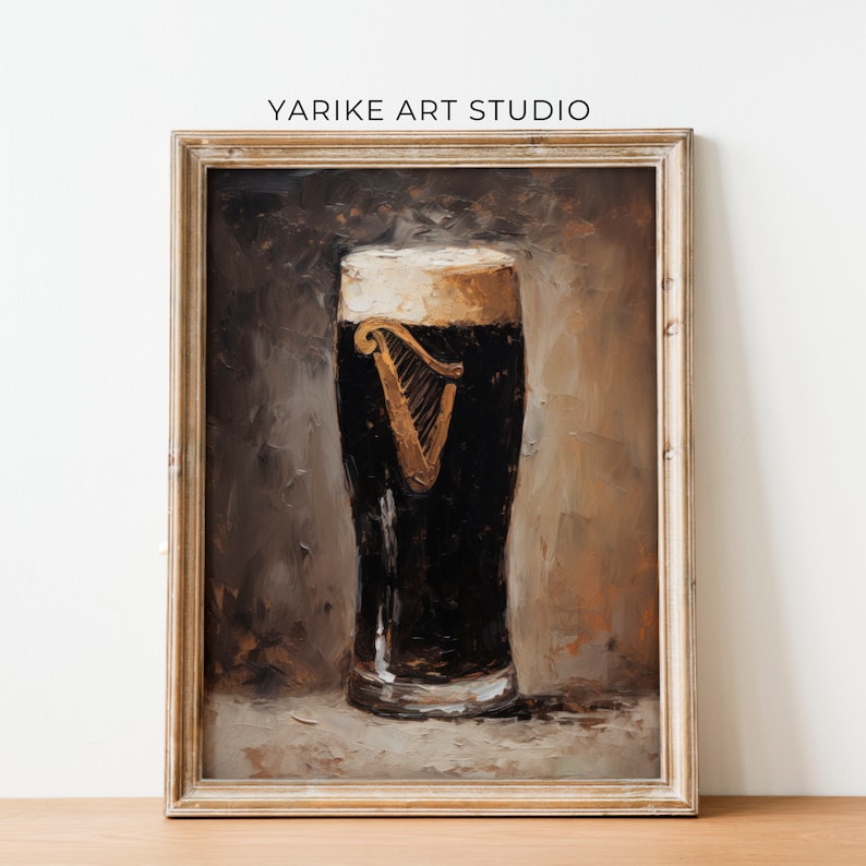 May include: A framed painting depicting a glass of Guinness beer with a white head. The beer is dark brown and the glass is clear. The background is a brown and tan colour.