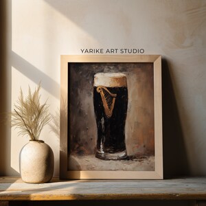 May include: A framed painting depicting a glass of Guinness beer with a white head. The painting is set against a brown background and has a rustic, vintage style.