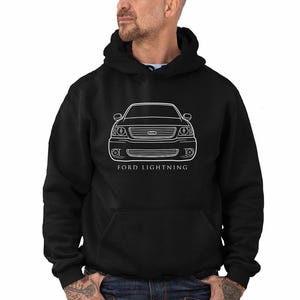 May include: Black hooded sweatshirt featuring a white outline of a Ford Lightning truck. The text "FORD LIGHTNING" is printed below the vehicle illustration. The sweatshirt has a front pocket and a drawstring hood.