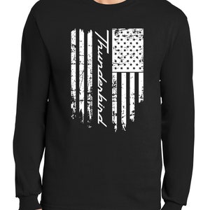 Puede incluir: Camiseta negra de manga larga con un diseño de bandera estadounidense blanca desgastada y la palabra "Thunderbird" impresa verticalmente en el lado izquierdo de la bandera.