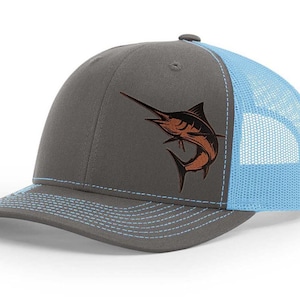 May include: A gray and light blue trucker hat with a brown marlin fish embroidered on the front.