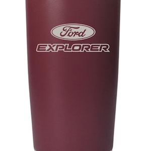 May include: A maroon stainless steel tumbler featuring the Ford logo and the word EXPLORER engraved in white. The cylindrical drinkware has a smooth matte finish on the body and a polished silver metallic rim at the top and a silver base at the bottom.