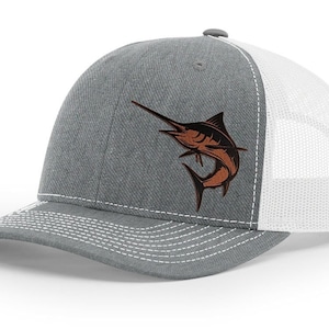 May include: A gray and white trucker hat with a brown marlin fish embroidered on the front.