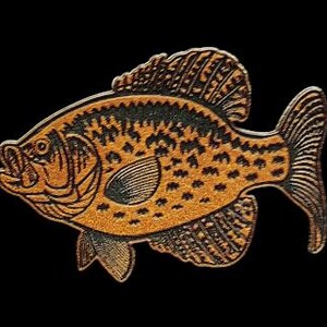 May include: A detailed, stylized fish illustration with a textured, golden-brown body and black markings. The fish has a detailed fin and tail design, set against a solid black background. The artwork is likely a pin or a decorative element.