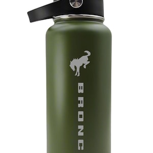Puede incluir: Botella de agua aislada verde oliva con tapa y asa negras. La botella presenta una silueta blanca de caballo y la palabra "BRONCO" impresa verticalmente. Diseñada para mantener las bebidas frías o calientes, tiene una capacidad de 946 ml.