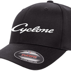 May include: Black baseball cap with a white "Cyclone" logo embroidered on the front. The cap has a Flexfit label on the back.