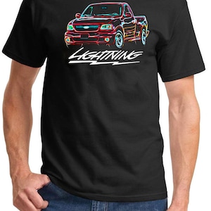 May include: A black t-shirt with a neon-colored graphic of a red Ford F-150 Lightning pickup truck. The text "LIGHTNING" is printed in white below the truck.