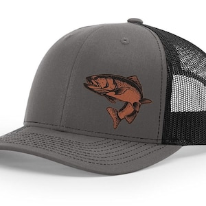 May include: A gray and black trucker hat with a brown embroidered fish design.