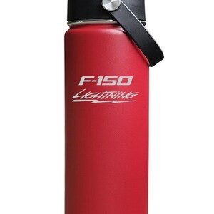 May include: A red insulated water bottle with a black lid and a black carrying handle. The front of the bottle features the white text F-150 and the word LIGHTNING written in a stylized script font with a lightning bolt graphic underneath.
