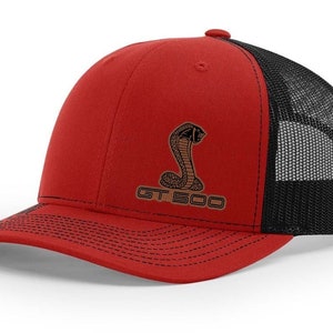 May include: Red and black trucker hat with a brown embroidered cobra and the text "GT 500".