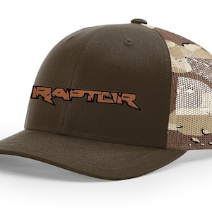 May include: A brown and tan camouflage trucker hat with a brown brim and a brown mesh back. The hat has a brown embroidered logo that says "RAPTEIR".