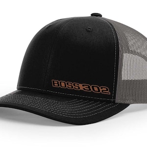 May include: Black and gray trucker hat with a brown embroidered logo that says "BOSS 302".