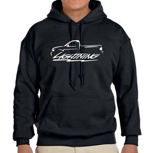 May include: Black hooded sweatshirt with a white silhouette of a Ford Lightning pickup truck and the word "Lightning" in a stylized font.