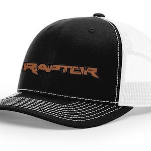May include: Black and white trucker hat with a brown embroidered "RAPTOR" logo.