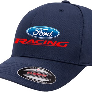 May include: A navy blue baseball cap with a white Ford Racing logo. The logo has a blue oval with the word "Ford" in white and the word "Racing" in red below the oval. The cap has a Flexfit label on the back.