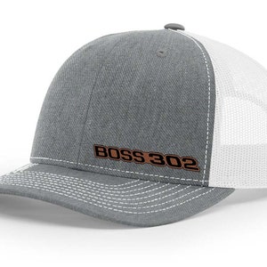 May include: A gray and white trucker hat with a brown leather patch that says "BOSS 302".
