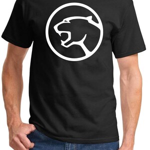 May include: Black t-shirt with a white circular logo featuring a stylised panther head.