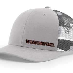 May include: A gray and white camouflage trucker hat with a brown embroidered "BOSS 302" logo.
