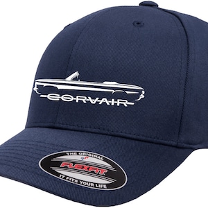 May include: A navy blue baseball cap with a white outline of a classic car and the text "Corvair" on the front. The cap has a Flexfit label on the back.