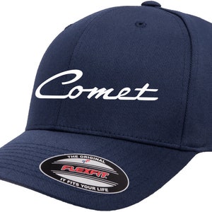 May include: A navy blue baseball cap with a white embroidered "Comet" logo. The cap features a Flexfit label on the underside of the brim.