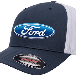 May include: A navy blue and white baseball cap with a white mesh back. The front of the cap features a blue oval with the word "Ford" in white lettering. The cap has a Flexfit label on the underside of the brim.