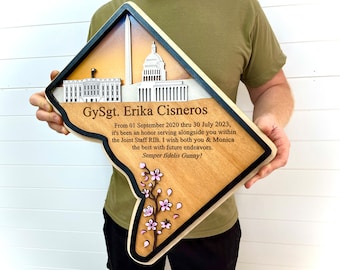 May include: A wooden plaque shaped like the state of Virginia with a black border. The plaque features a 3D image of the Washington Monument, the White House, and the Capitol Building. The plaque also includes a personalized message for GySgt. Erika Cisneros, thanking her for her service and wishing her well in her future endeavors. The message reads: "From 01 September 2020 thru 30 July 2023, it's been an honor serving alongside you within the Joint Staff RIB. I wish both you & Monica the best with future endeavors. Semper fidelis Gunny!"